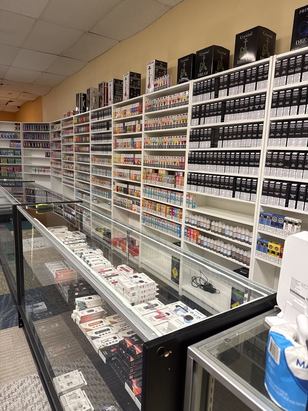 The counter and e-liquid shelves inside Golden Vape & Smoke in Littleton